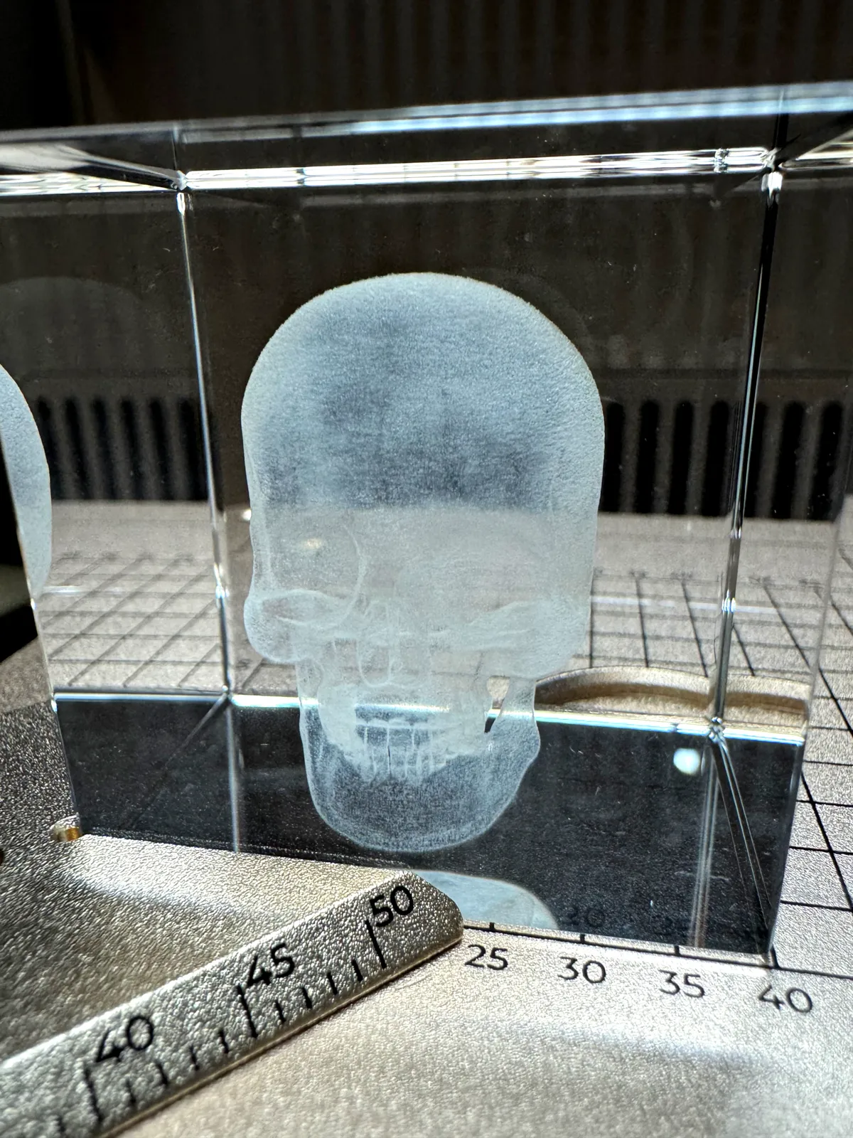 3D-Innengravur eines Totenkopfs in einem Kristallwürfel
